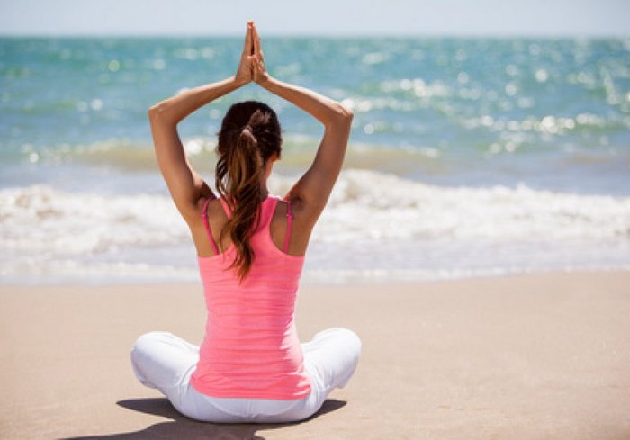 junge-Frau-am-Meer-in-Yogahaltung-pirituelle-reise-Südindien