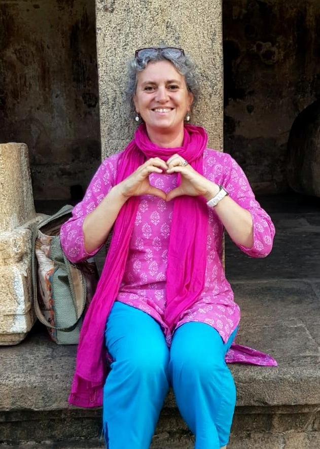 Daniela sitz in einem südindischen Tempel während der spirituellen Indienreise und zeigt ein Herz